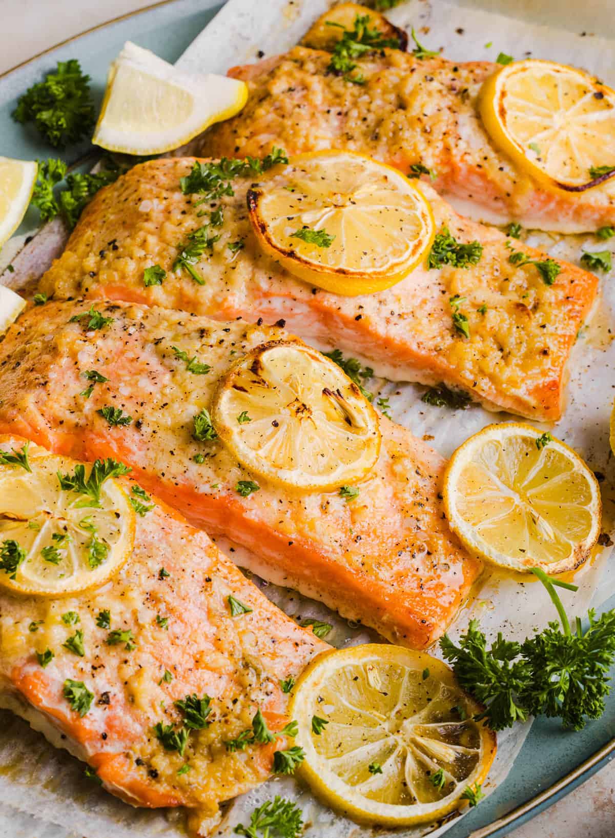 The most flavorful Garlic Butter Baked Salmon that is tender, flaky and coated in a rich garlicky sauce with lemon and Dijon. This simple healthy recipe easily comes together in under 20 minutes!